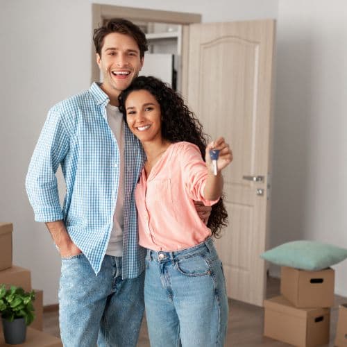 New homeowners holding the keys to the house they had inspected